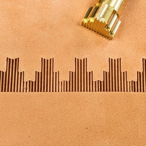 May include: A close-up of a leather craft tool with a textured surface. The tool is used to create a decorative pattern on leather. The pattern is a series of vertical lines that create a cityscape effect.