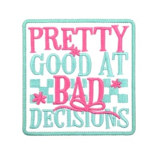 May include: Embroidered patch with the phrase "PRETTY GOOD AT BAD DECISIONS" in pink and teal. The patch has a teal border and a checkered pattern. Decorative floral accents and a pink bow add detail.