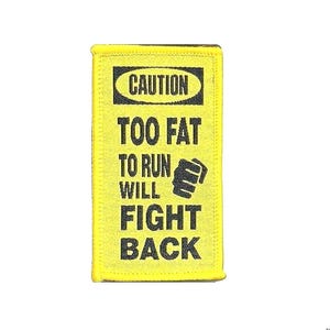 May include: Yellow rectangular patch with black text that reads "CAUTION TOO FAT TO RUN WILL FIGHT BACK". The patch has a black fist graphic. The patch has a yellow border.