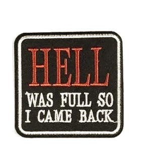 May include: Black square patch with white border. The patch features the word "HELL" in red, above the text "WAS FULL SO I CAME BACK" in white. The patch is likely for a jacket or bag.