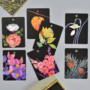 May include: Set of ten black and white tarot cards featuring various floral and botanical illustrations. Each card has a unique design with a different flower or plant.