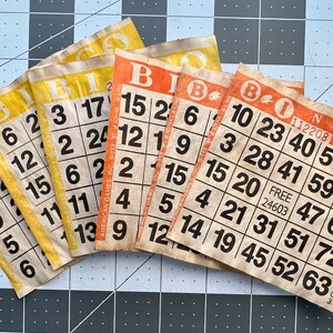 Cartones de bingo naranja y amarillo teñidos de café