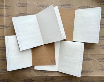 May include: Several open notebooks with white pages and brown covers are arranged on a surface. Each notebook has a numbered tab on the side. The background features repeated text: "HANDMADE BY TRADMARKCREATIONS TRADMARKART."