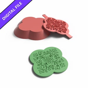 Op de afbeelding: Een digitaal bestand voor een klavervormige mal en stempelset. De set bevat een effen roze klavervormige mal, een roze stempel met een ingewikkeld bloemmotief en een groen klavervormig stuk met hetzelfde gedetailleerde bloemmotief in reliëf.
