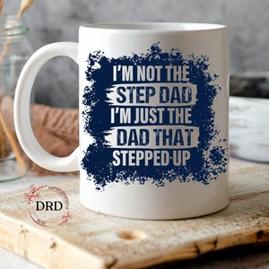 May include: White ceramic coffee mug with a blue and white design. The text on the mug reads "I'm not the step dad I'm just the dad that stepped up".