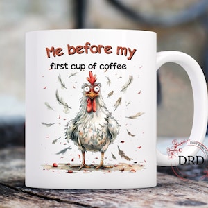 May include: White ceramic coffee mug with a cartoon chicken illustration and the text "Me before my first cup of coffee".