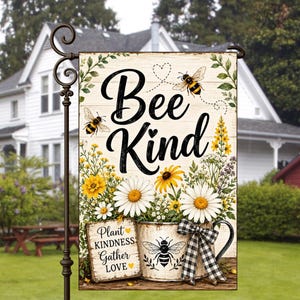 May include: A rectangular garden flag featuring the text Bee Kind, Plant Kindness, Gather Love, and illustrations of bees, yellow and white daisies, and a rustic mug with a black and white checkered bow, all set against a light wood background.