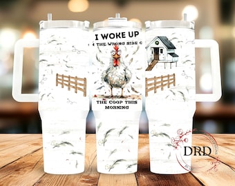 May include: White stainless steel tumbler with a white chicken, a coop, and a fence. The tumbler has a white lid and a white handle. The text on the tumbler reads "I woke up on the wrong side of the coop this morning".