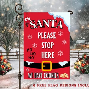 May include: A red Christmas garden flag with the words "SANTA PLEASE STOP HERE" in white. The flag features snowflakes, Santa climbing a ladder, and a belt design. The phrase "WE HAVE COOKIES" is also included.