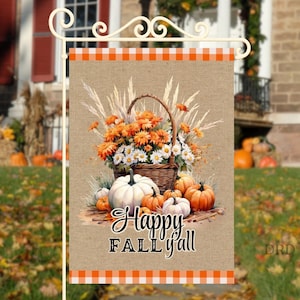 May include: A fall-themed garden flag with a basket of orange and white flowers and pumpkins. The flag has the words "Happy Fall Y'all" in a script font. The top and bottom borders are orange and white checkered.