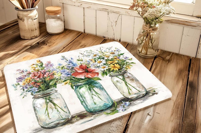 May include: A rectangular decorative mat featuring a watercolor painting of three mason jars filled with colorful wildflowers. The jars are clear with silver lids, and the flowers include red, yellow, blue, and purple blooms.