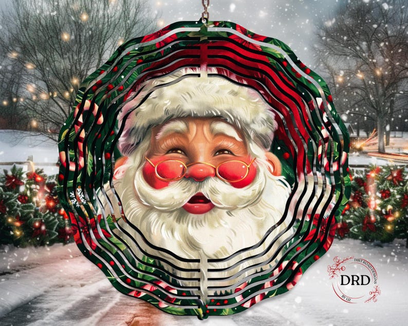 Puede incluir: Adorno navide&ntilde;o decorativo con la cara de Pap&aacute; Noel. El adorno tiene un dise&ntilde;o en capas con detalles en rojo, verde y blanco. Pap&aacute; Noel lleva gafas con montura dorada y barba blanca. El fondo muestra una escena invernal nevada.