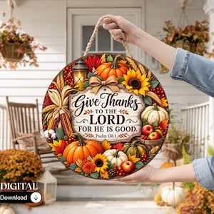 May include: A round wooden sign featuring a fall harvest theme with pumpkins, sunflowers, autumn leaves, and a lantern. The center text reads Give Thanks TO THE LORD FOR HE IS GOOD. Psalm 136:1. The sign includes a rope hanger for display.