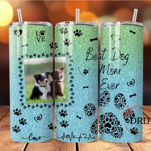 May include: A turquoise and green glitter tumbler with a paw print design and the text "Best Dog Mom Ever". The tumbler has a photo of two dogs in a frame.