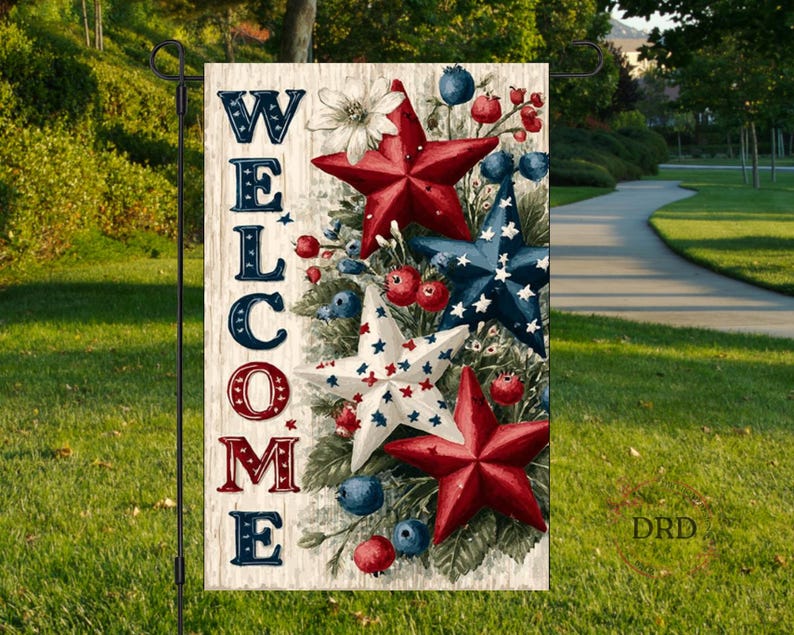 Pu&ograve; includere: Una bandiera da giardino con la scritta "WELCOME" in lettere rosse, bianche e blu. La bandiera presenta stelle, bacche e fiori rossi, bianchi e blu. La bandiera &egrave; esposta su un supporto in metallo nero in un giardino.