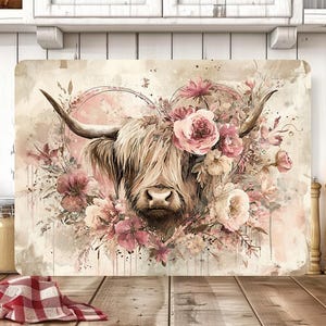 Peut inclure: Planche à découper rectangulaire avec une illustration à l'aquarelle d'une vache des Highlands ornée d'une couronne florale de roses roses et crème. La vache a de longs poils hirsutes brun clair et de grandes cornes.