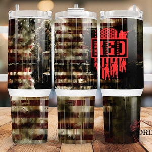 May include: Three stainless steel tumblers with a white handle and lid. The tumblers feature a distressed American flag design with a soldier in the background. The text "Remember Everyone Deployed" is printed in red on the right tumbler.