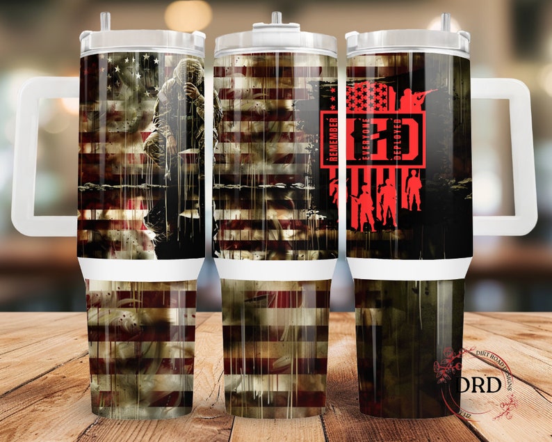 May include: Three stainless steel tumblers with a white handle and lid. The tumblers feature a distressed American flag design with a soldier in the background. The text "Remember Everyone Deployed" is printed in red on the right tumbler.