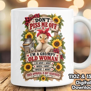 May include: A white ceramic mug featuring a graphic of a duck wearing a red bandana, surrounded by sunflowers and a wooden fence. The text reads: DON'T PISS ME OFF, I'M A GRUMPY OLD WOMAN, I DO WHAT I WANT WHEN I WANT WHERE I WANT, YOUR APPROVAL IS NOT REQUIRED.