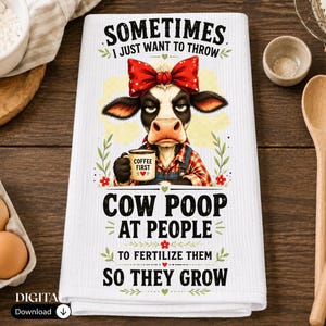 May include: A white waffle-weave kitchen towel featuring a graphic of a cow wearing a red bow and a plaid shirt, holding a mug labeled COFFEE FIRST. The text reads SOMETIMES I JUST WANT TO THROW COW POOP AT PEOPLE TO FERTILIZE THEM SO THEY GROW.