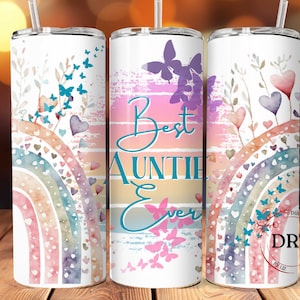 Könnte beinhalten: Drei weiße Edelstahlbecher mit einem Regenbogen, Herzen, Schmetterlingen und dem Text "Best Auntie Ever" in blaugrün.
