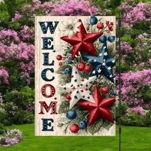 Pu&ograve; includere: Una bandiera da giardino con la scritta "WELCOME" in lettere rosse, bianche e blu. La bandiera presenta stelle rosse, bianche e blu, bacche e accenti floreali. La bandiera &egrave; esposta su un supporto in metallo nero in un giardino.