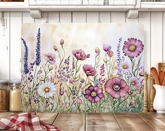 May include: A rectangular cutting board featuring a watercolor floral design. The artwork showcases a field of purple, pink, and white flowers, including daisies and lavender, against a soft, off-white background. The board is set on a wooden surface.