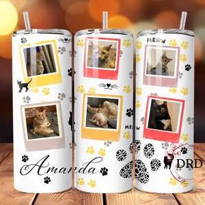 May include: White stainless steel tumbler with a personalized name "Amanda" and a paw print design. The tumbler features multiple photos of cats in a Polaroid style frame with a yellow, pink, and gray color scheme. The tumbler has a straw and is perfect for cat lovers.