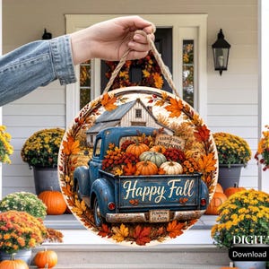 May include: A round wooden sign featuring a blue vintage pickup truck filled with pumpkins, surrounded by autumn leaves. The truck bed displays the text Happy Fall, and a sign reads Farm Fresh Pumpkins. It hangs from a jute rope for display.