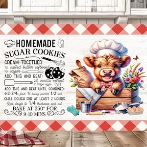 May include: A wooden sign with a red and white gingham border. The sign displays a sugar cookie recipe, a cartoon calf in a chef's hat, and baking-themed illustrations. Measurements are in imperial units.