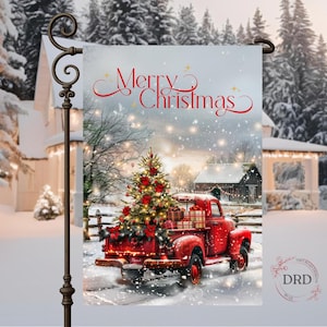 Puede incluir: Una bandera de jardín navideña con un camión rojo vintage que transporta un árbol de Navidad decorado y regalos. La bandera tiene las palabras "Merry Christmas" en letras rojas sobre una escena invernal nevada con una casa y un granero.