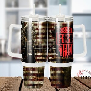 May include: A white stainless steel tumbler with a handle and a straw. The tumbler has a design of an American flag with a soldier in front of it. The text "Remember Everyone Deployed" is on the tumbler.