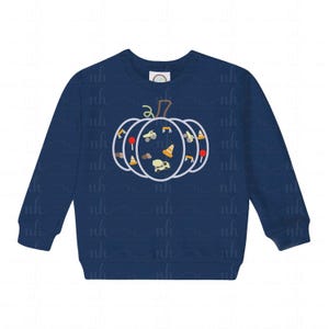 Può includere: Felpa blu navy con un design a forma di zucca. La zucca, delineata in bianco, è riempita di grafiche a tema costruzione, tra cui una betoniera, coni stradali e un bulldozer. La felpa ha un girocollo e maniche lunghe.