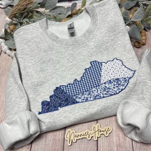 Quiltad tröja med statlig applikation