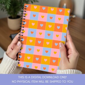K&ouml;nnte beinhalten: Ein Spiralnotizbuch mit einem farbenfrohen, sich wiederholenden Muster aus Herzen in orangefarbenen, rosa, gelben und blauen Quadraten. Das Notizbuch ist ge&ouml;ffnet und zeigt das Design. Text unten: DIES IST NUR EIN DIGITALER DOWNLOAD, ES WERDEN KEINE PHYSISCHEN ARTIKEL AN SIE VERSENDET.