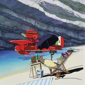 May include: An animated scene depicts a red seaplane with an Italian flag on its tail, parked near a beach. A person relaxes in a beach chair under a black umbrella, with a radio and drinks on a small table. A striped towel lies on the sand.
