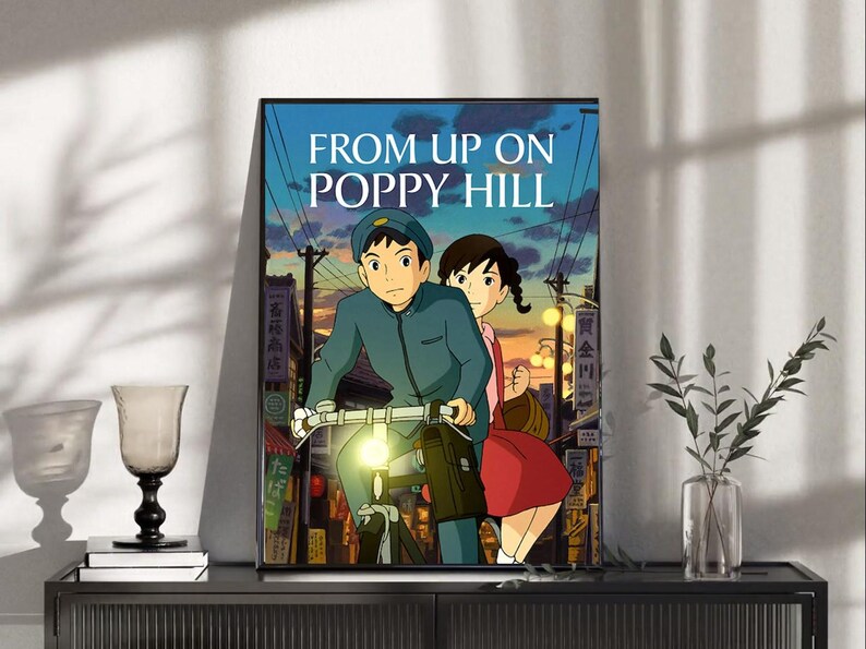 Puede incluir: P&oacute;ster enmarcado de la pel&iacute;cula de anime "La colina de las amapolas". La obra muestra a un joven en bicicleta con una joven detr&aacute;s, ambientados en un paisaje urbano al atardecer. El t&iacute;tulo "FROM UP ON POPPY HILL" est&aacute; en blanco.