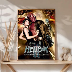 May include: A framed movie poster for "Hellboy: Legions of Doom" featuring Hellboy and a woman. The poster has a dark, action-oriented design with the title prominently displayed. The poster is on a wooden shelf with a teddy bear and decorative items.
