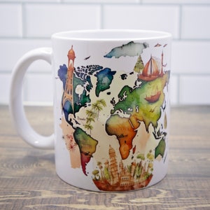 Może przedstawiać: Biały kubek ceramiczny z wzorem akwarelowej mapy świata. Mapa przedstawia zabytki z całego świata, w tym wieżę Eiffla, Tadź Mahal i Wielki Mur Chiński.