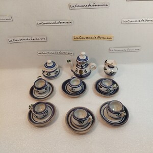 Peut inclure: Un service à thé miniature avec des motifs floraux bleus et blancs. L'ensemble comprend une théière, un pot à crème, un sucrier et quatre tasses à thé et soucoupes.