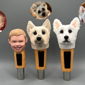 May include: Three custom-made beer tap handles. One features a child's face, another a white dog with brown ears, and the last a white dog with white ears.