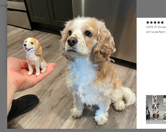 May include: A white and brown Cavalier King Charles Spaniel dog sitting on a wooden floor. A smaller figurine of a dog is being held in a person's hand. The text "LOVE IT! So excited it isn't a perfect match" is visible in the image.