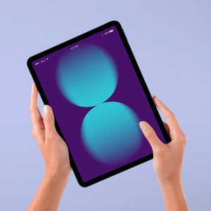 Op de afbeelding: Een persoon houdt een tablet vast met een paarse achtergrond en twee overlappende blauwe cirkels. De tijd op het scherm is 16:21.