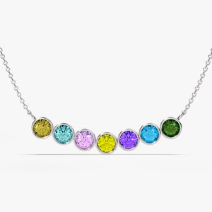 May include: A silver chain necklace with seven round gemstones in different colors: yellow, blue, purple, yellow, purple, blue, and green.