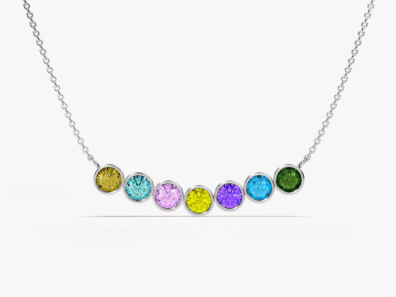 May include: A silver chain necklace with seven round gemstones in different colors: yellow, blue, purple, yellow, purple, blue, and green.