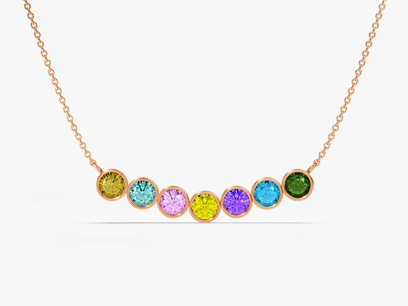 May include: A gold chain necklace with seven round gemstones in a rainbow of colors: yellow, blue, pink, yellow, purple, blue, and green.