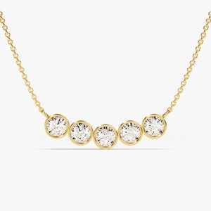 May include: A gold chain necklace with five round bezel-set diamonds.