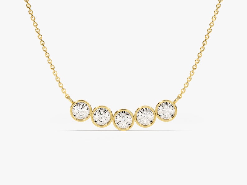 May include: A gold chain necklace with five round bezel-set diamonds.