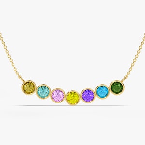 May include: A gold chain necklace with seven round gemstones in a rainbow of colors: yellow, blue, pink, yellow, purple, blue, and green.