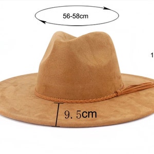K&ouml;nnte beinhalten: Ein brauner Fedora-Hut aus Wildleder mit einem geflochtenen Band und einem Quaste. Der Hut hat einen 9,5 cm breiten Rand und ist 12 cm hoch. Die Hutgr&ouml;&szlig;e betr&auml;gt 56-58 cm.